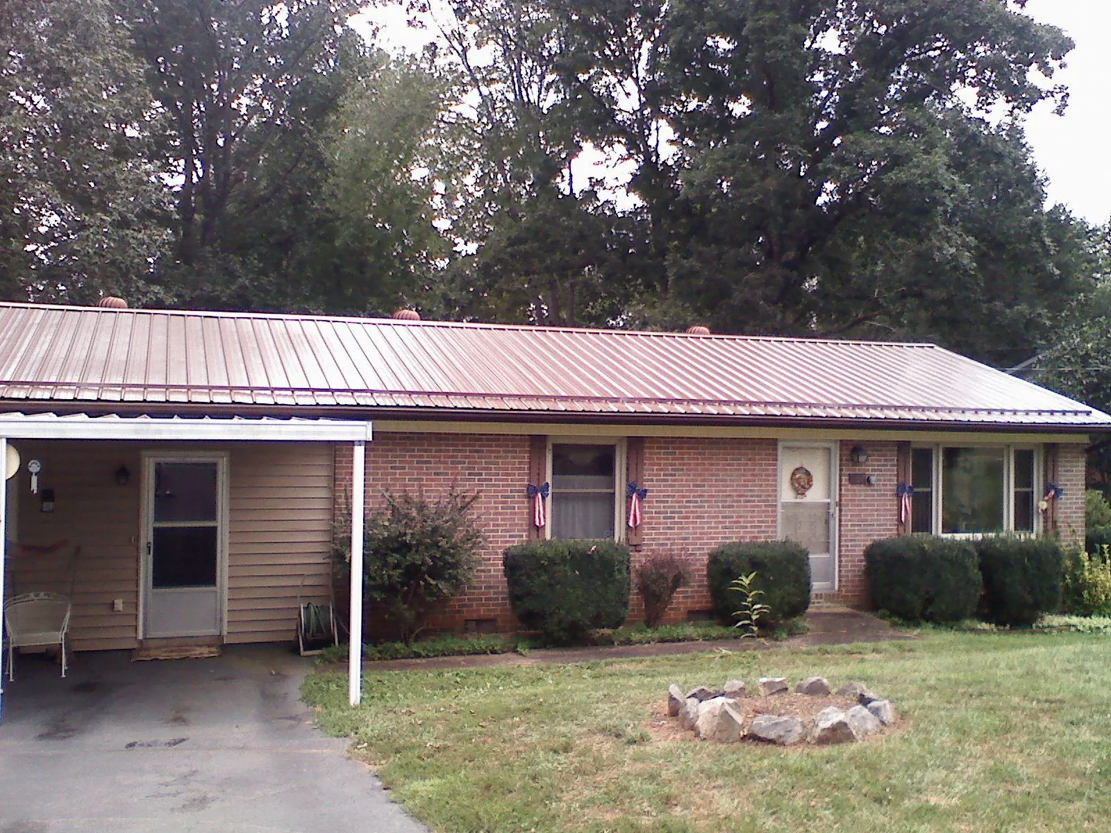 Bronze metal roof and carport on a brick ranch home — Roof Repair work by our crew in Churchville